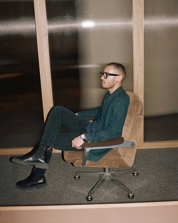 Rochdi Kachem, manager of Zürich’s Monocle café, sitting sideways on a brown corduroy chair