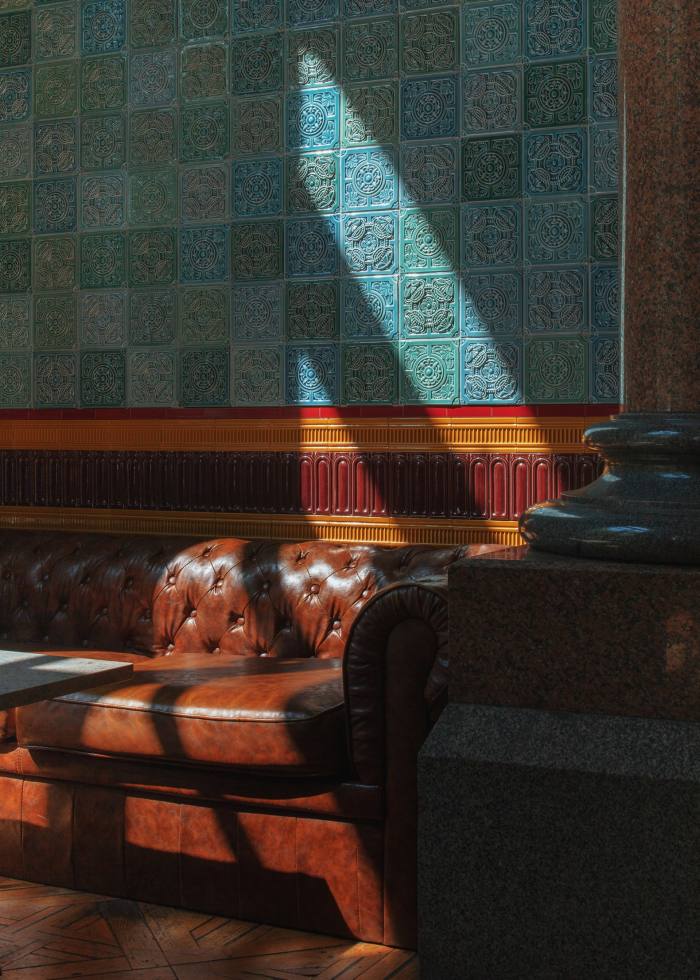 A plush leather-covered bench inside an old-style pub