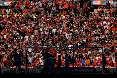 Luton Town fans in the stands shield their eyes from the sun during the Sky Bet Championship play-off final against Coventry City at Wembley Stadium.