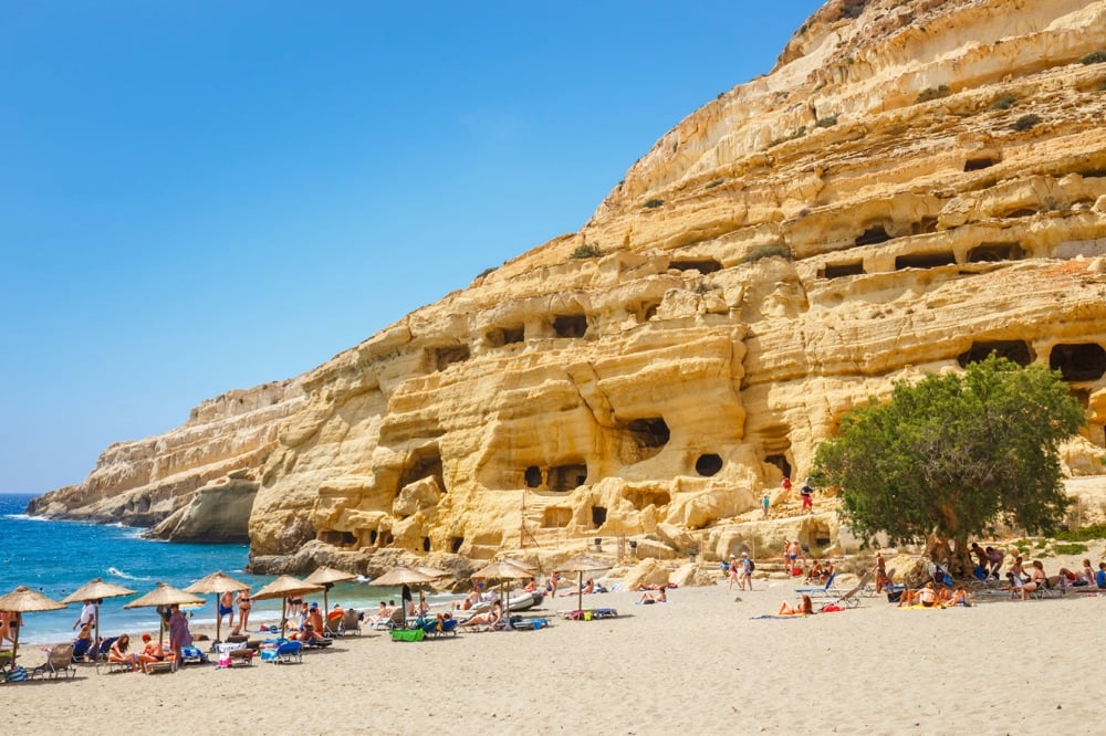 Weathered cliffs over the beach at Matala. Spending a day in the sand is one of my favorite things to do in Crete, Greece.