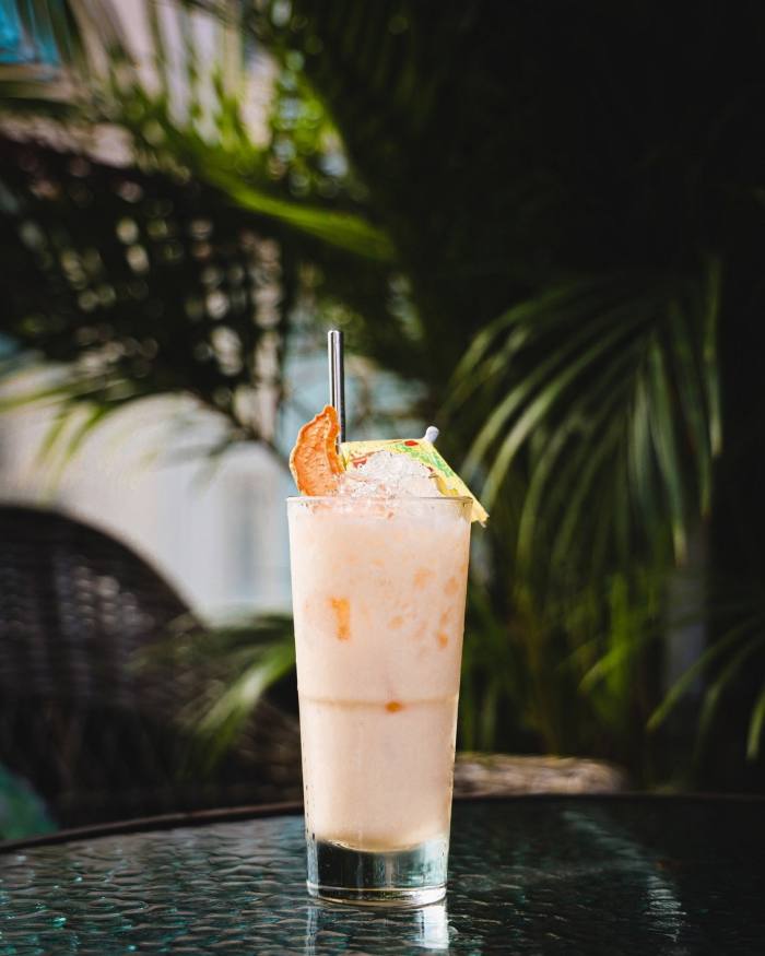 Ohana’s Quick Fix cocktail – an orange and cream drink with a paper umbrella sitting on top of crushed ice