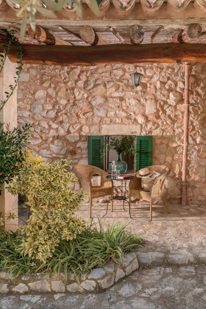 A chair and table against the stonework walls of the hotel