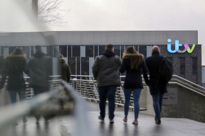 Pedestrians cross a footbridge heading to ITV studios