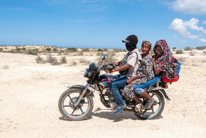 Three people on a motorbike