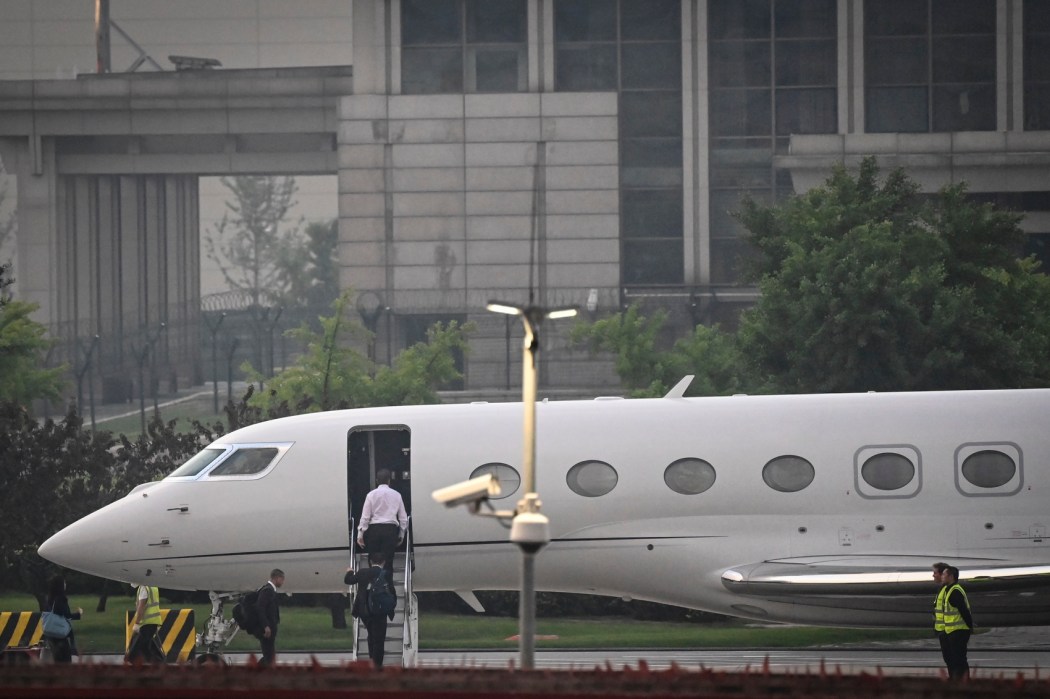 Tesla Chief Executive Officer Elon Musk (in white) boards his private jet before departing from Beijing Capital International Airport on May 31, 2023. Photo: Jade Gao/AFP.