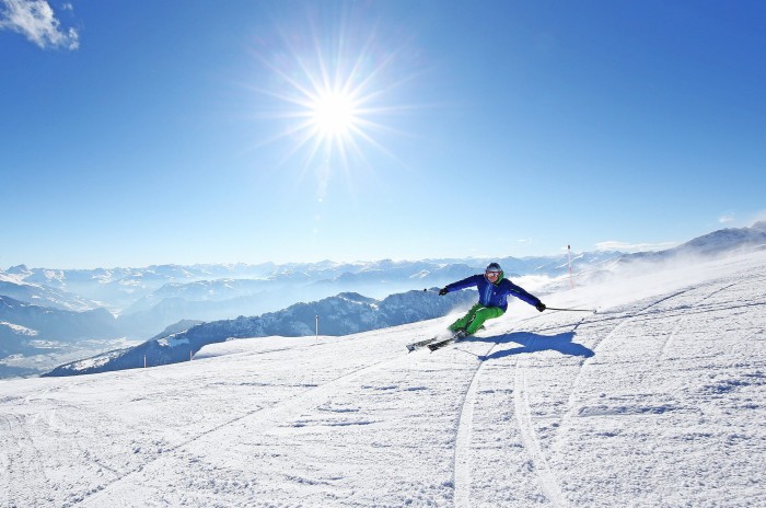 A lone skier on a piste in Pizol beneath a blue sky on a sunny day