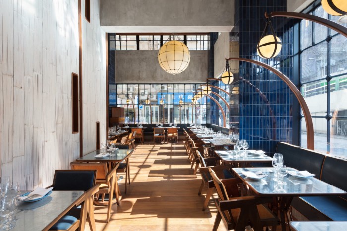 The bistro in Hong Kong’s The Fleming, with patterned smooth concrete walls, large windows and globe lamps