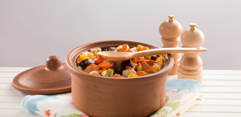 A mix vegetables on casserole and a wood spoon on the top. 