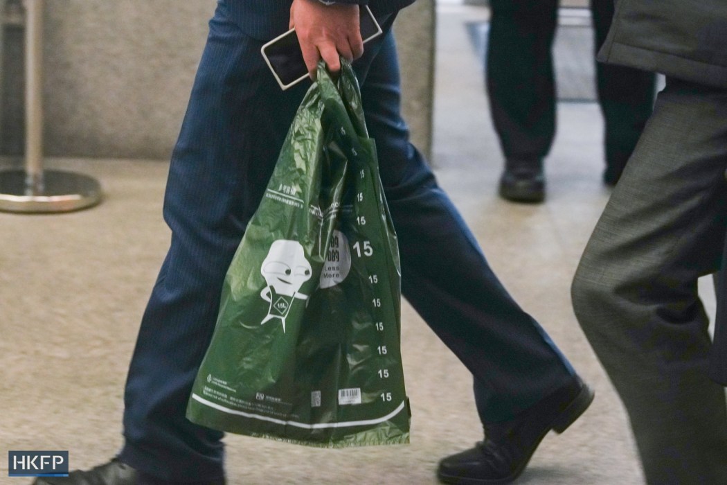 A person carrys a designated disposal bag authorised by the government under the new municipal solid waste charge scheme on January 26, 2024. Photo: Kyle Lam/HKFP.