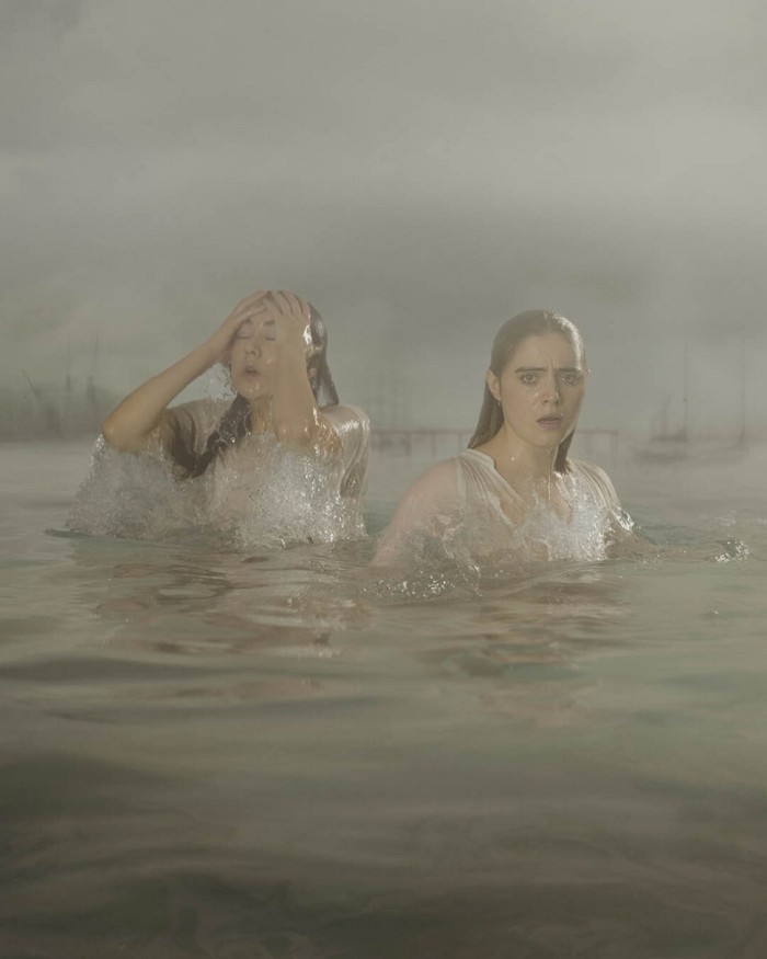 Actors Ami Tredrea and Bella Maclean semi-submerged in misty waters in ‘London Tide’