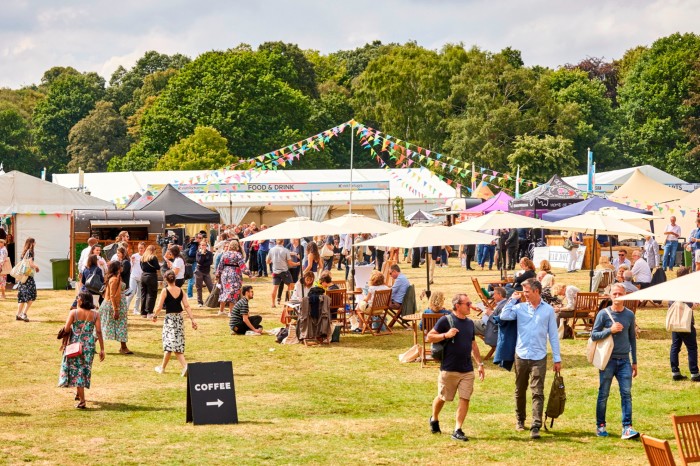 Attendees walking over a lawn around tents and stalls at last year’s FT Weekend Festival