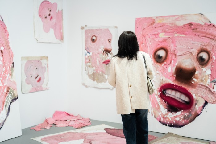 A woman looking at ‘Untitled’ by Iranian artist Farrokh Mahdavi at the National Gallery of Victoria’s Triennial – large pink abstract human faces in broad strokes