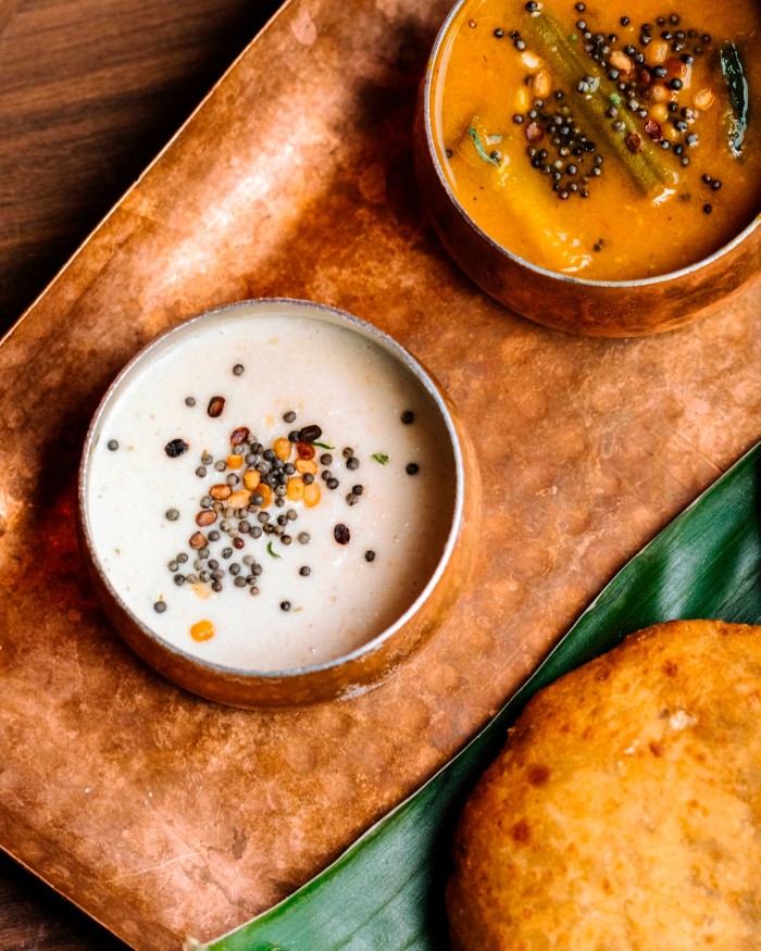 Banana bun with bowls of coconut chutney and sambar at Bangera’s Kitchen Ginza