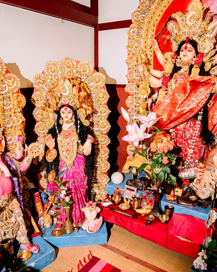 Colourful statuettes of female Hindu deities in a corner of Puja