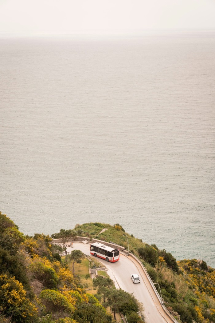 Looking down on a car and a coach on a winding coastal road