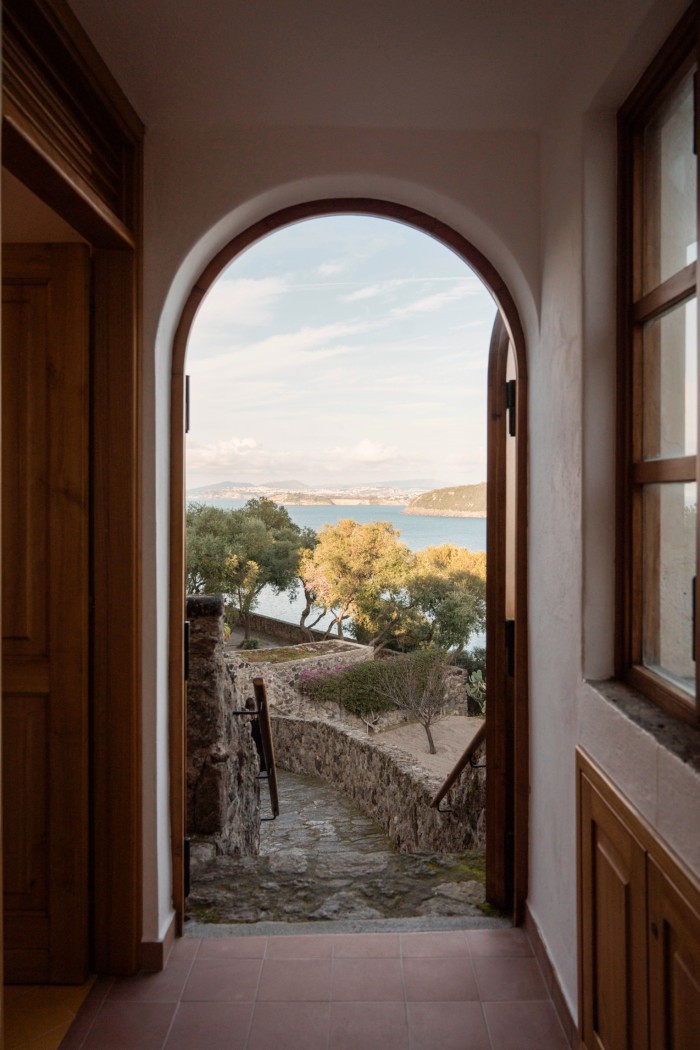 A view through a doorway to trees and sea