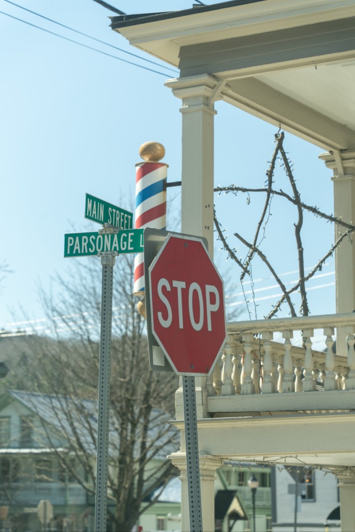 Street signs and a stop sing near white painted buildings