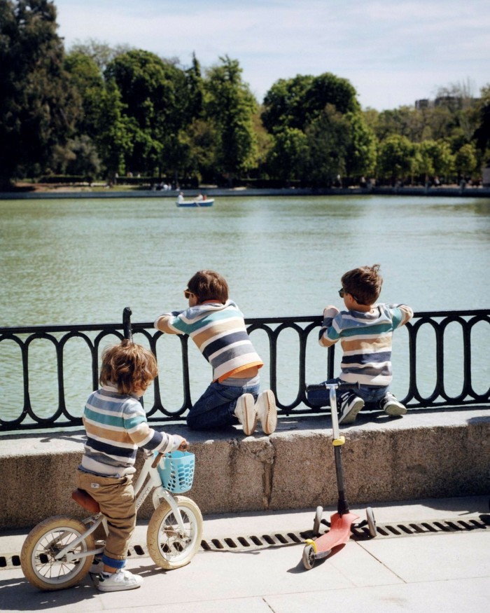 Three small children on a bridge crossing the park’s boating lake