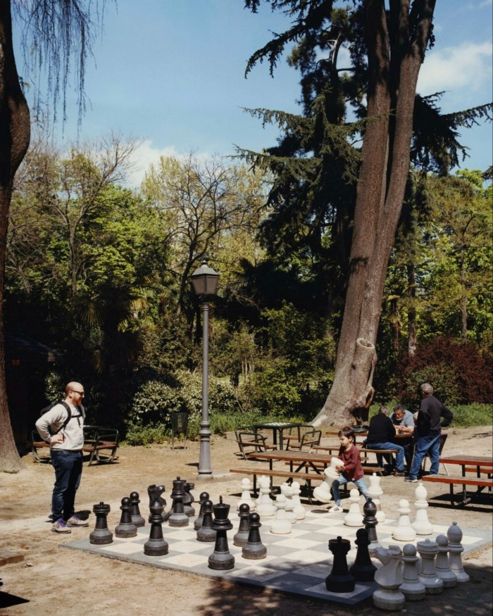  A man and a boy playing chess on a supersized board in El Retiro