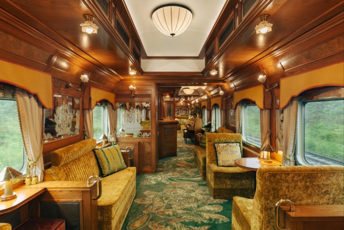 A rail carriage with velvet upholstered seating and patterned carpet