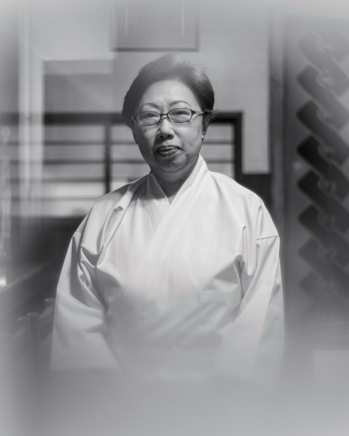 A black and white photograph of Chef Yukiko Okuzumi of Edo-mae Mimatsu wearing chef’s whites