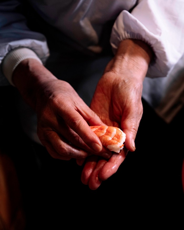 The hands of chef Sachiko Shimizu preparing a shrimp nigiri at Wakana Sushi