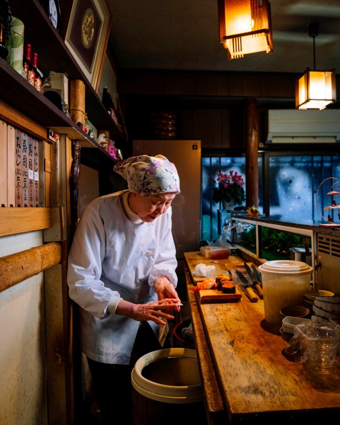 Chef Sachiko Shimizu behind the wooden counter of her restaurant Wakana Sushi