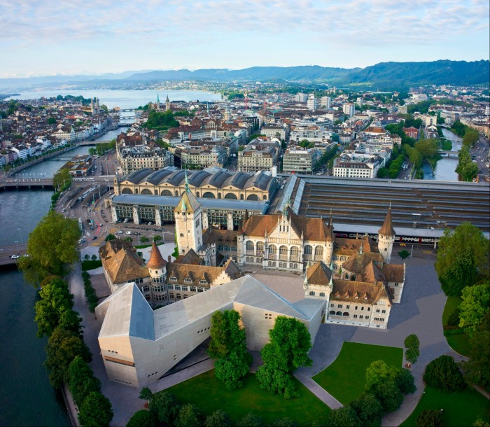 Aerial shot of the Swiss National Museum in Zürixh, with the river running alongside it and the lake in the distance