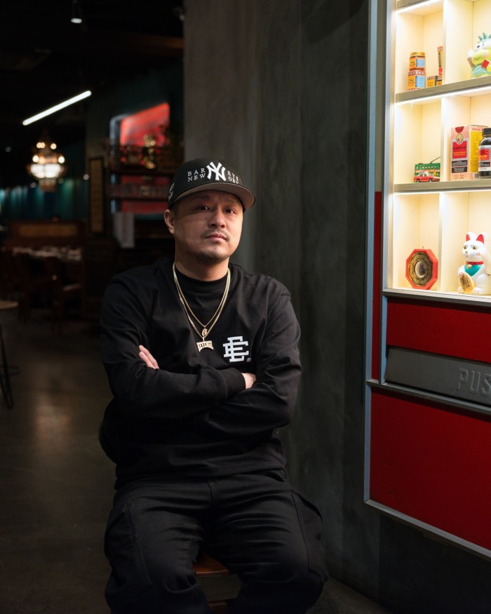 Potluck Club co-owner Cory Ng wearing black clothing, gold chains around his neck and a baseball cap