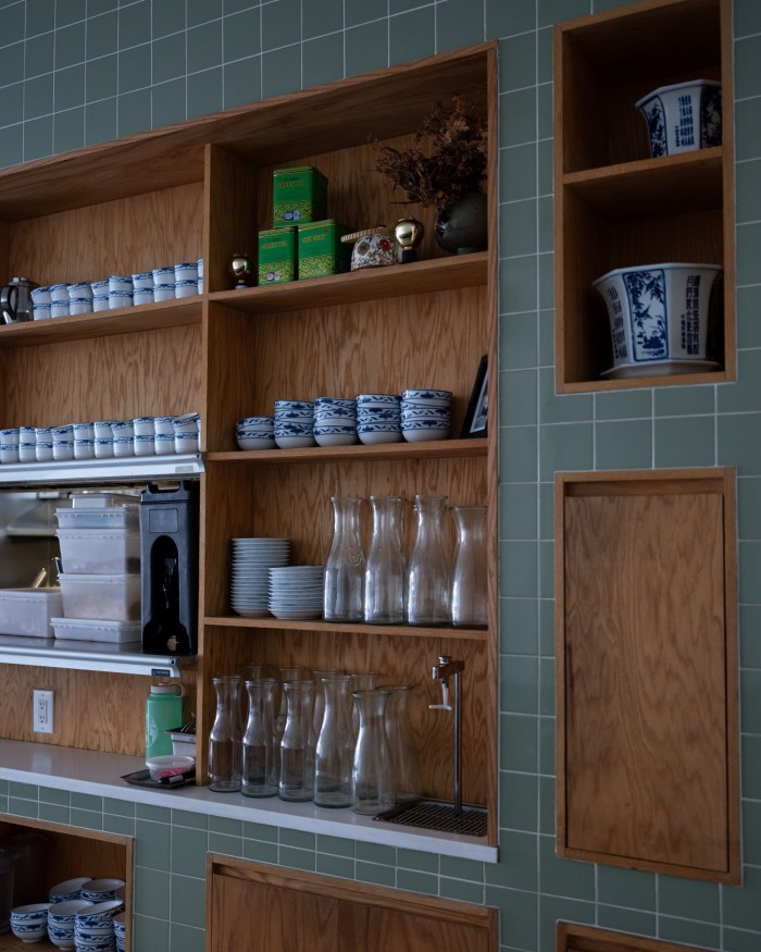 Wooden shelves of bowls, small plates and glass water bottles at Bonnie’s