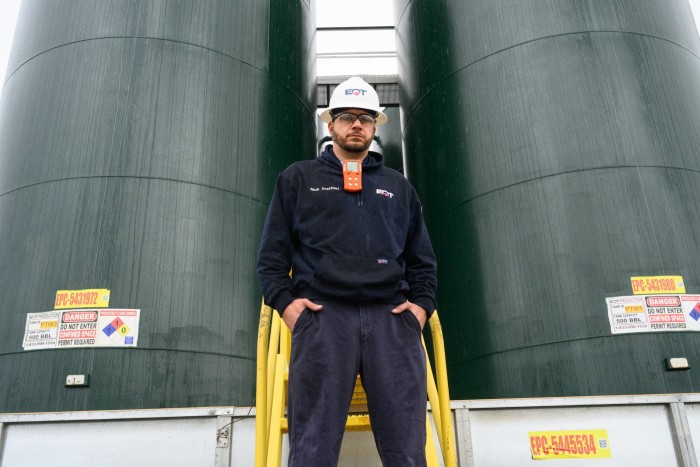Nick Staffieri stands in front of water towers at one of EQT’s natural gas well pads in Washington County, Pennsylvania