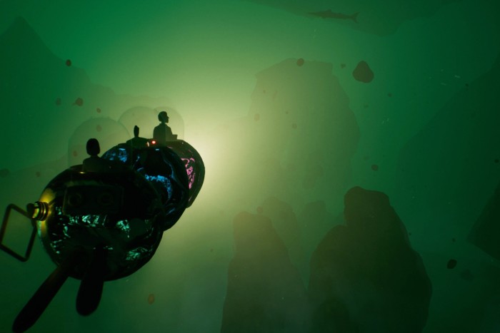 An image from a video game shows small figures sitting atop a vessel, constructed from three connected spheres, that is making its way through a green realm, seemingly under water; a light on the front of the vessel glows