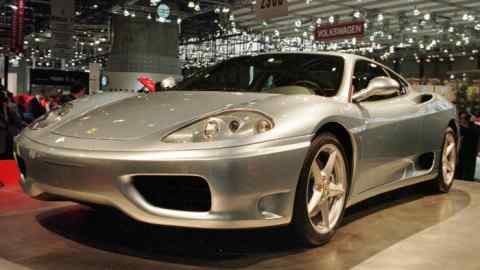 A Ferrari 360 Modena is displayed at a motor show