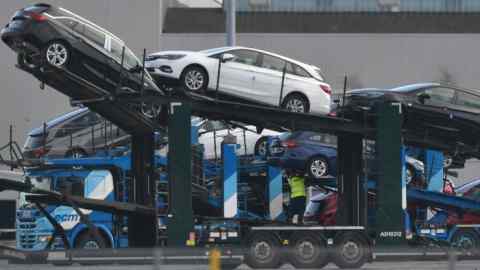 An employee secures vehicles on a transporter at the Vauxhall plant in Ellesmere Port