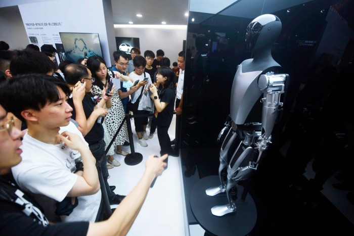Visitors to an AI conference in Shanghai last year view Tesla’s humanoid Optimus