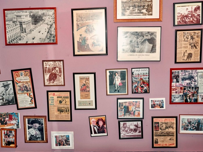 Framed vintage bullfighting photographs and articles of different sizes on a lilac-coloured wall at Casa Toni