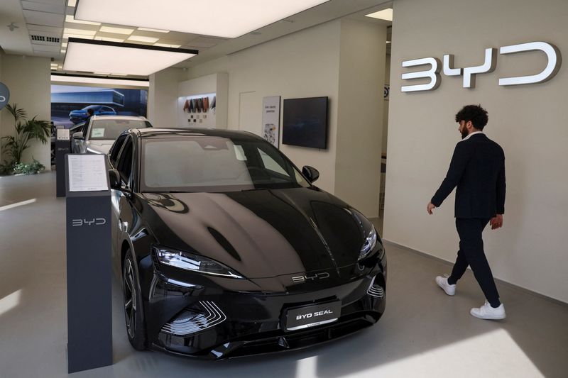 © Reuters. FILE PHOTO: A person walks next to BYD Seal car in a BYD Auto company and Autotorino store in Milan, Italy, March 20, 2024. REUTERS/Claudia Greco/File Photo