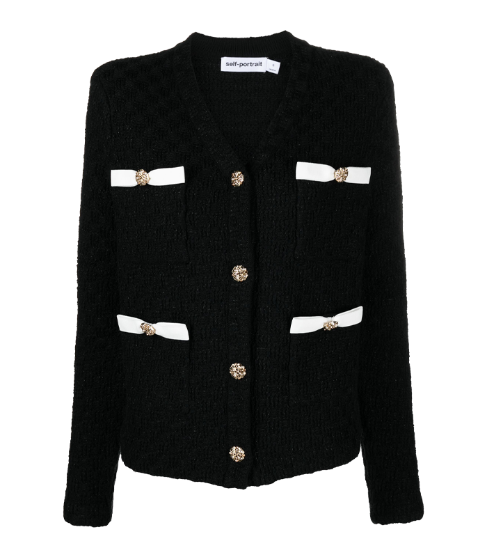 A black cardigan decorated with bows and gold coloured buttons