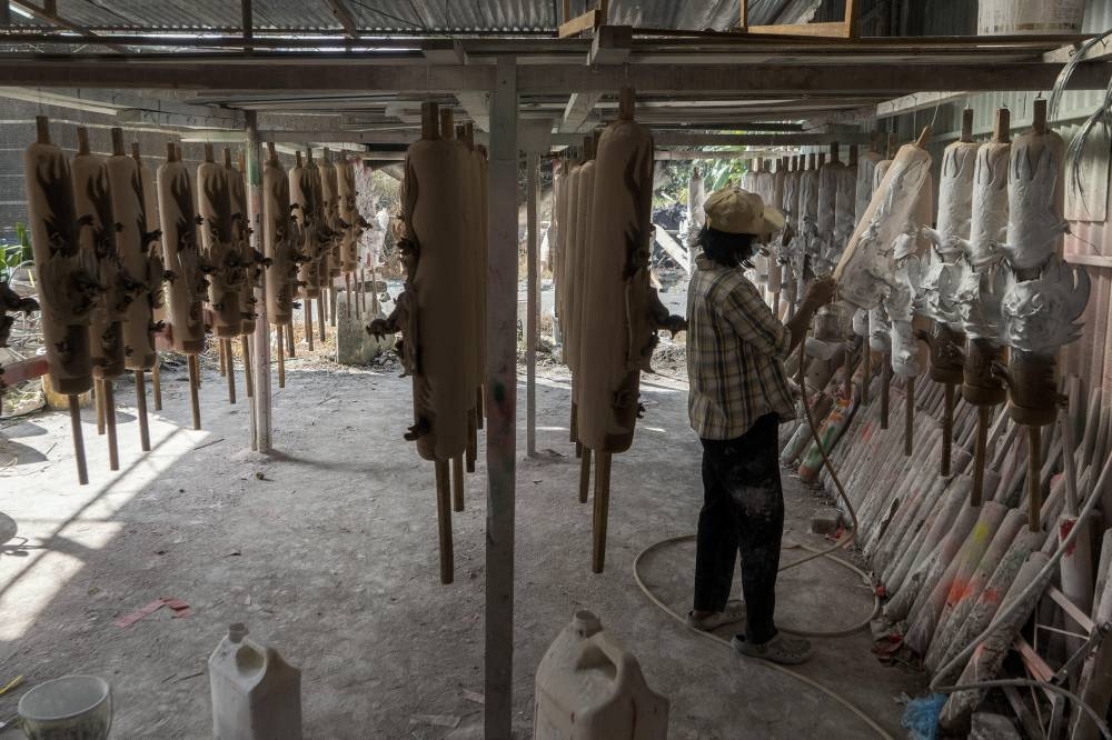 A worker painting the base of a joss stick. — Picture by Shafwan Zaidon