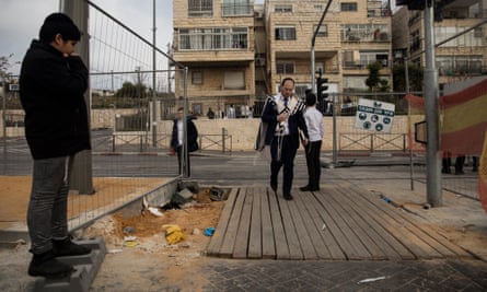 An Orthodox jewish man passes the scene of the mass shooting in Neve Yaakov.