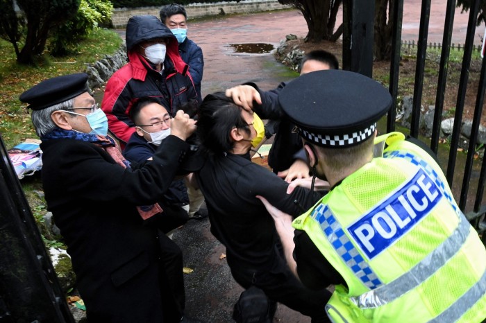 Police intervene in a scuffle between a Hong Kong pro-democracy protester and Chinese consulate staff in Manchester in October 2022