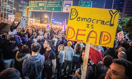 A protester holds a placard in a demonstration in Tel Aviv on Saturday night 