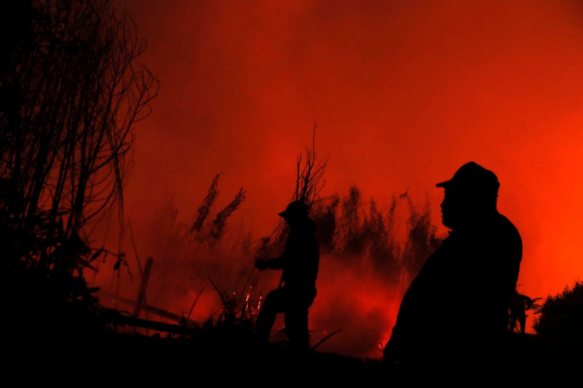 Residents clear debris after a wildfire swept through the area in Santa Juana, Chile, on Feb. 4, 2023.  (AP)