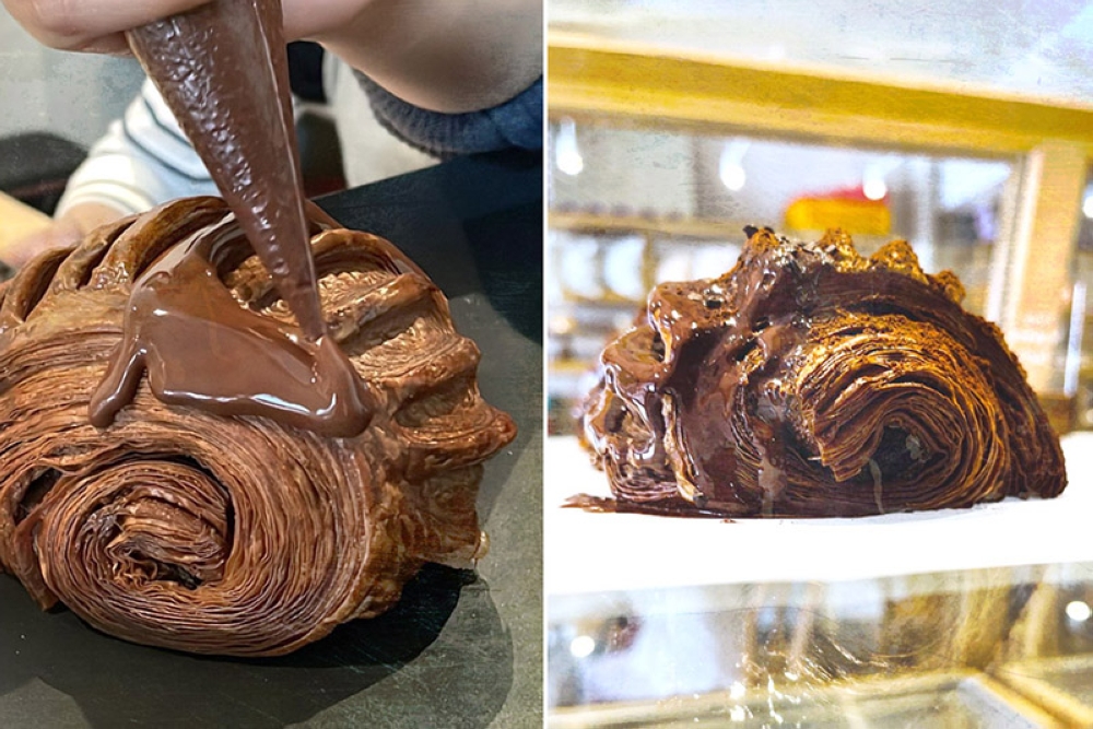 Cake Jalan Tiung’s 'pain au chocolat' getting a decadent drizzle of chocolate ganache.