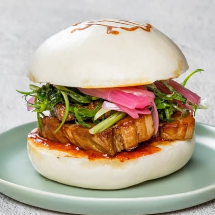 A pork belly bao burger seasoned with sesame and lemongrass barbecue sauces, shiso, and pickled red onions at Petite Bao in Vancouver, the brainchild of Jay Yip and Jessica Hui, a Hong Kong couple. Photo: Petite Bao
