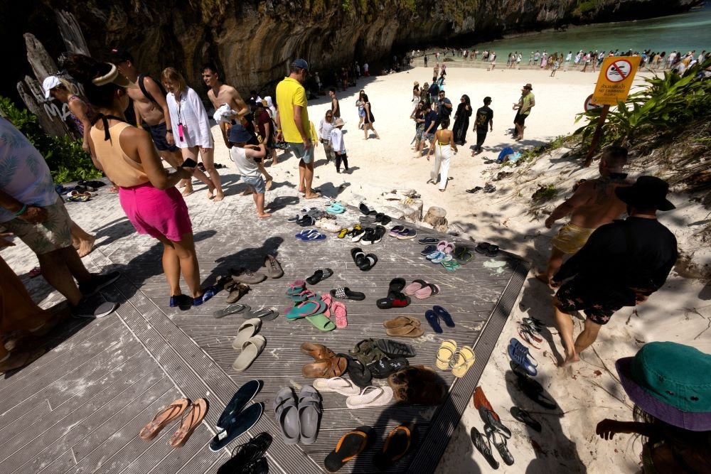Tourists enter the beach for an hour-long visit, where swimming is forbidden and people are only allowed to enter water up to their knees, in Maya Bay at the Phi Phi Island National Park, on Phi Phi Leh Island, Krabi province, Thailand February 28, 2023. — Reuters pic