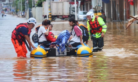 Flood-stranded people are rescued by a civilian rescue team with a rubber boat in Quanzhou, Fujian province, on Saturday