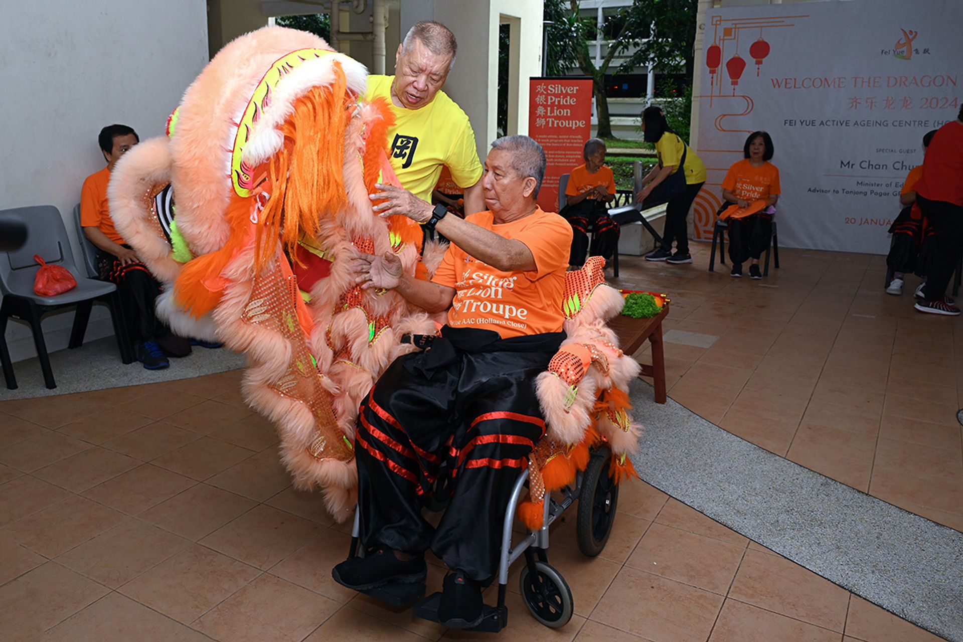 Mr Chia Chiang Teck (seated in wheelchair) getting into costume before the troupe’s debut performance.