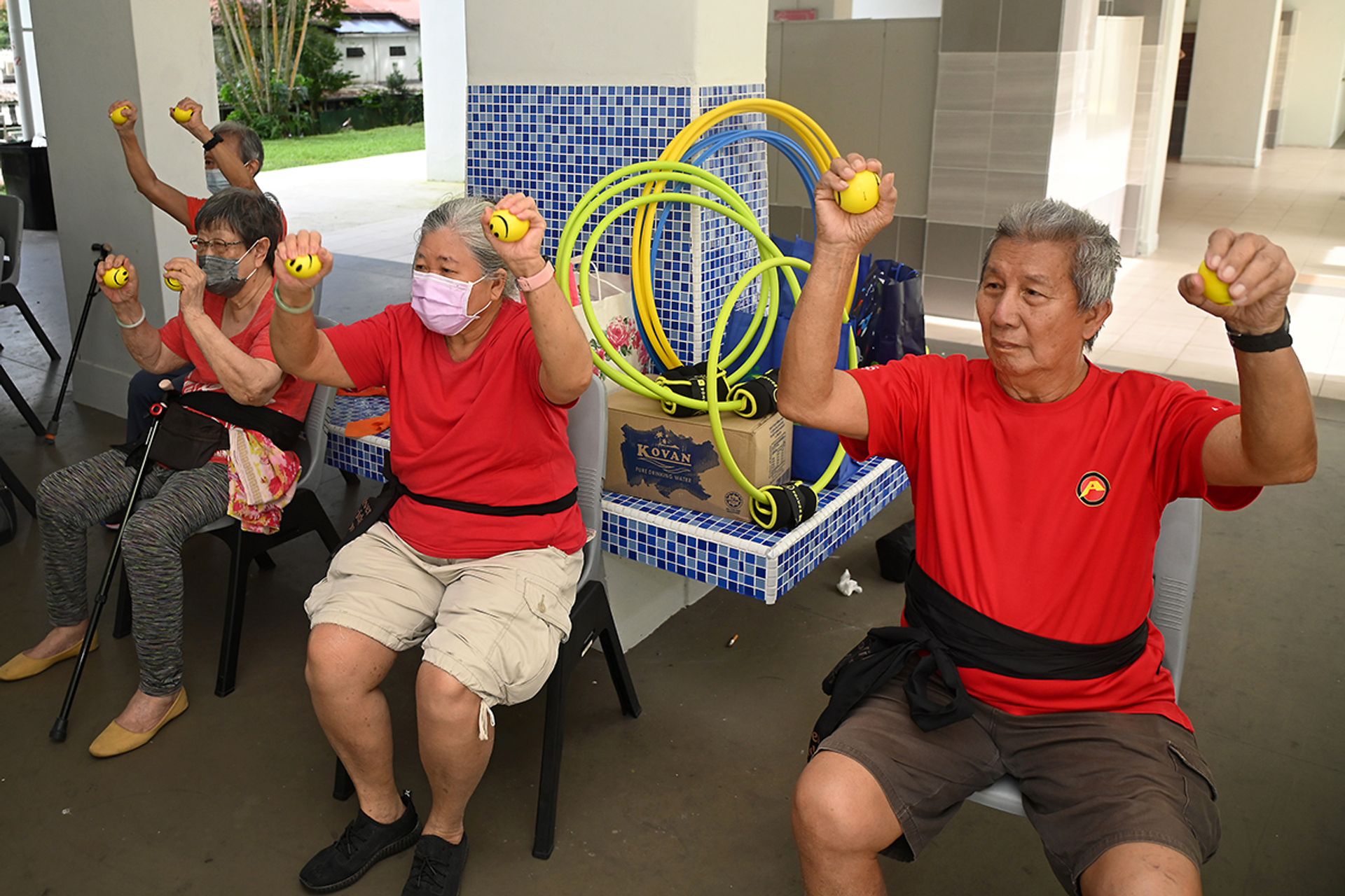 Mr Chia Chiang Teck (right) taking part in a grip strength training exercise using stress balls, alongside fellow seniors.
