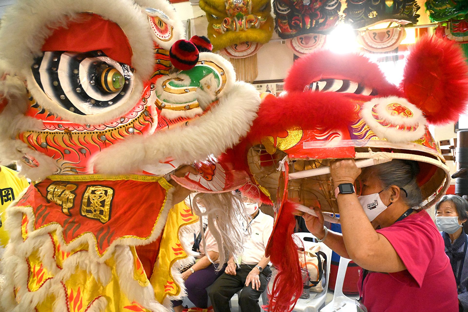 Madam Wong Seow Yoong, 69, learning the dos and don’ts when two lion dance troupes meet, alongside a fellow senior during an excursion to Kong Chow Wui Koon on Dec 15, 2023. The seniors also learnt about the heritage of lion dance and how to play cymbals to the drum beat.